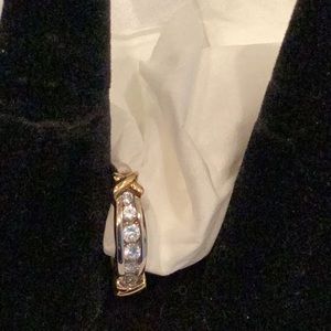 Cubic zirconia ring with gold tone X’s .